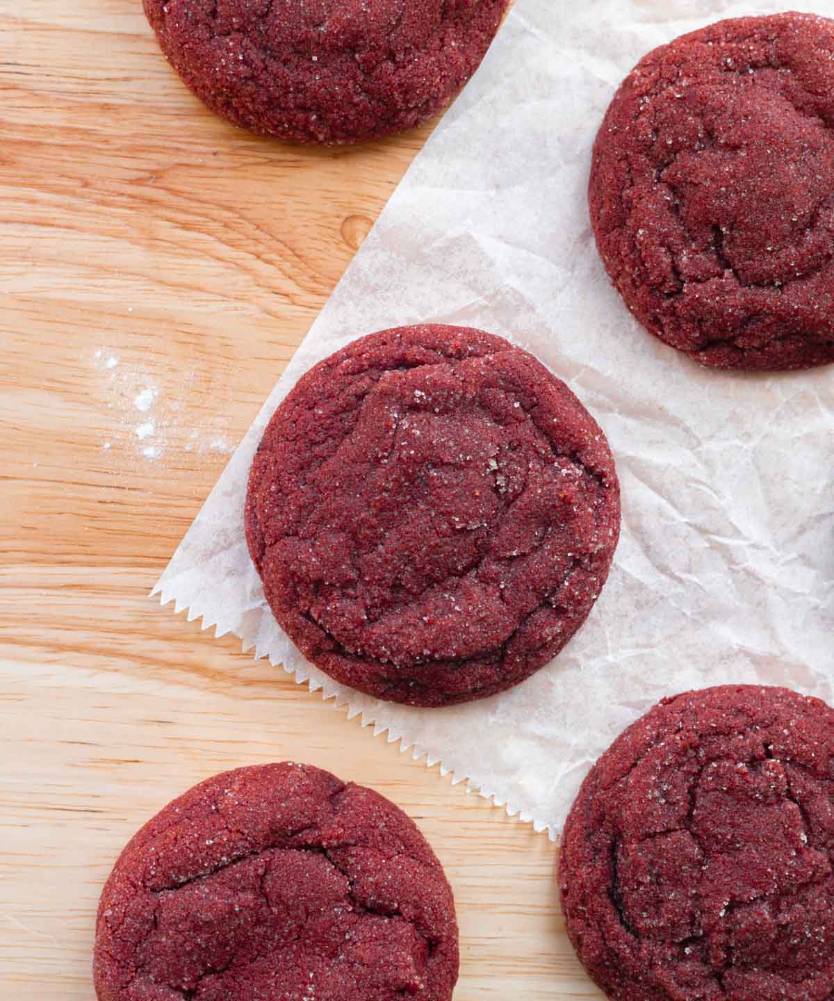 Red velvet sugar cookies on parchment paper.