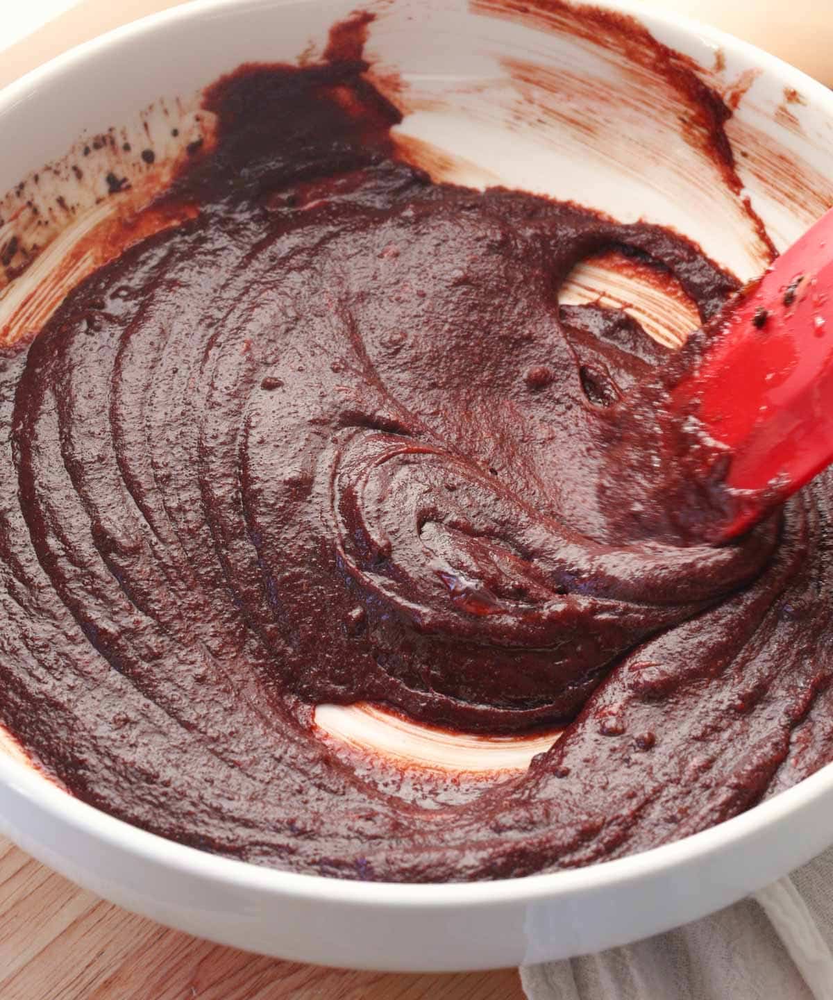 Mixed red velvet sugar cookie wet ingredients in white bowl.