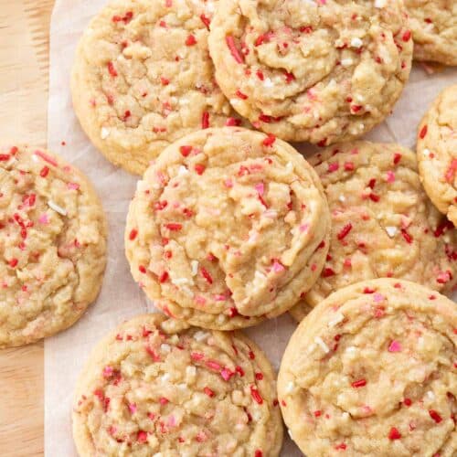 Valentine's Day sprinkle sugar cookies on white parchment paper.