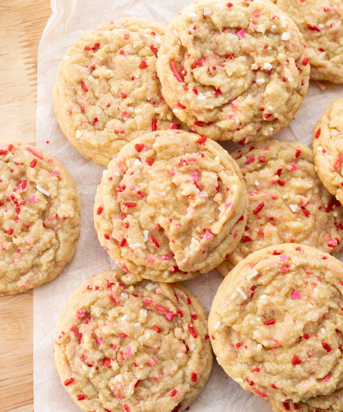 Valentine's Day sprinkle sugar cookies on white parchment paper.