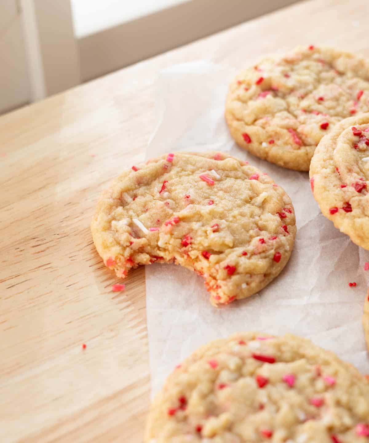 Cute heart sprinkle cookies; one has a bite taken out of it.