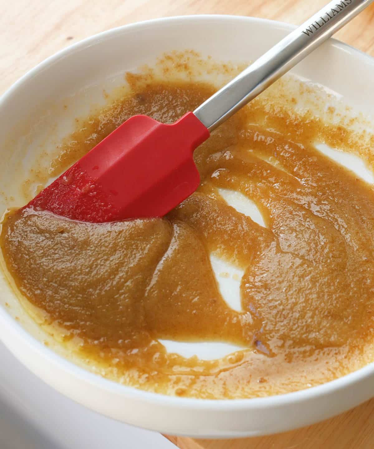 Melted butter mixed with sugars in white mixing bowl.