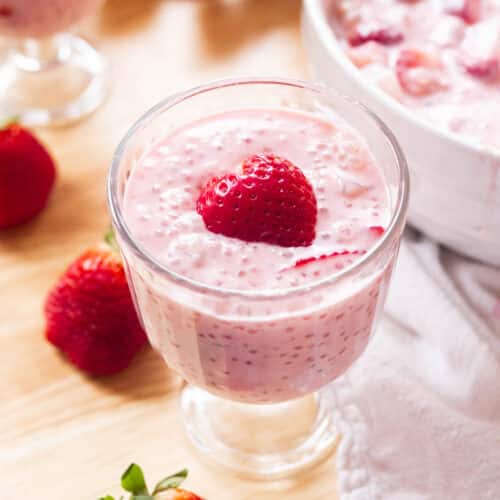 Pink strawberry sago in a glass cup with a strawberry heart on top.