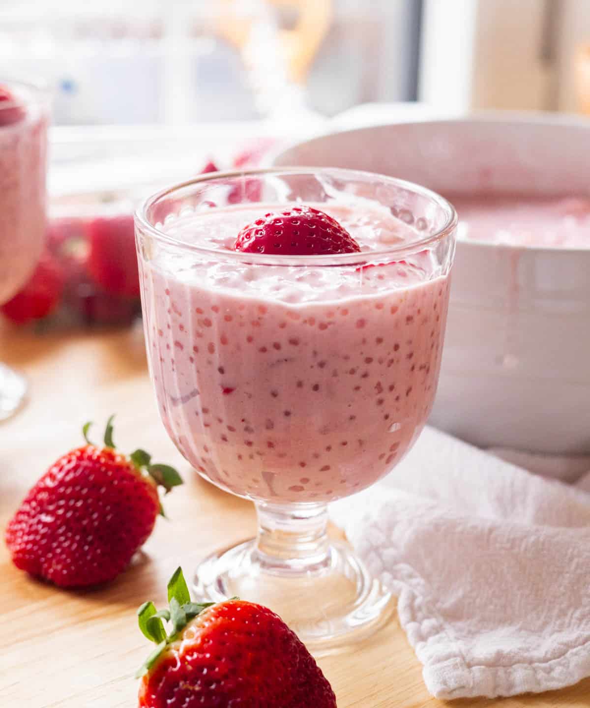 Strawberry sago in a glass cup with a strawberry heart on top.