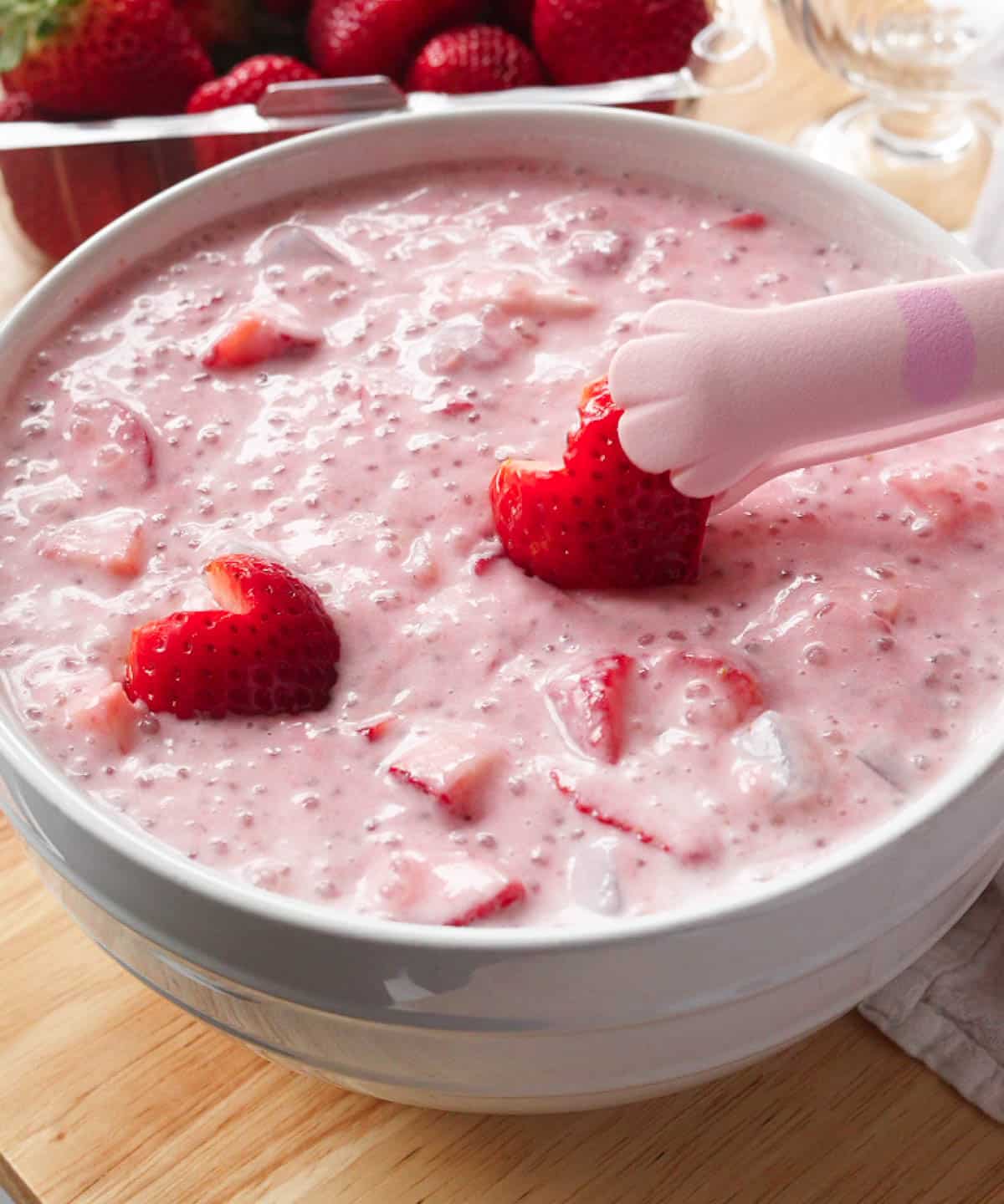 Adding cut strawberry hearts on top of delicious strawberry sago!