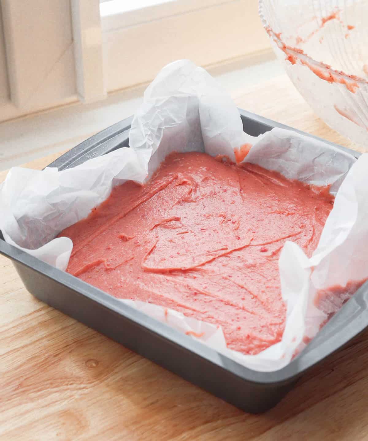 Pink brownie batter in baking pan, ready to go in the oven.