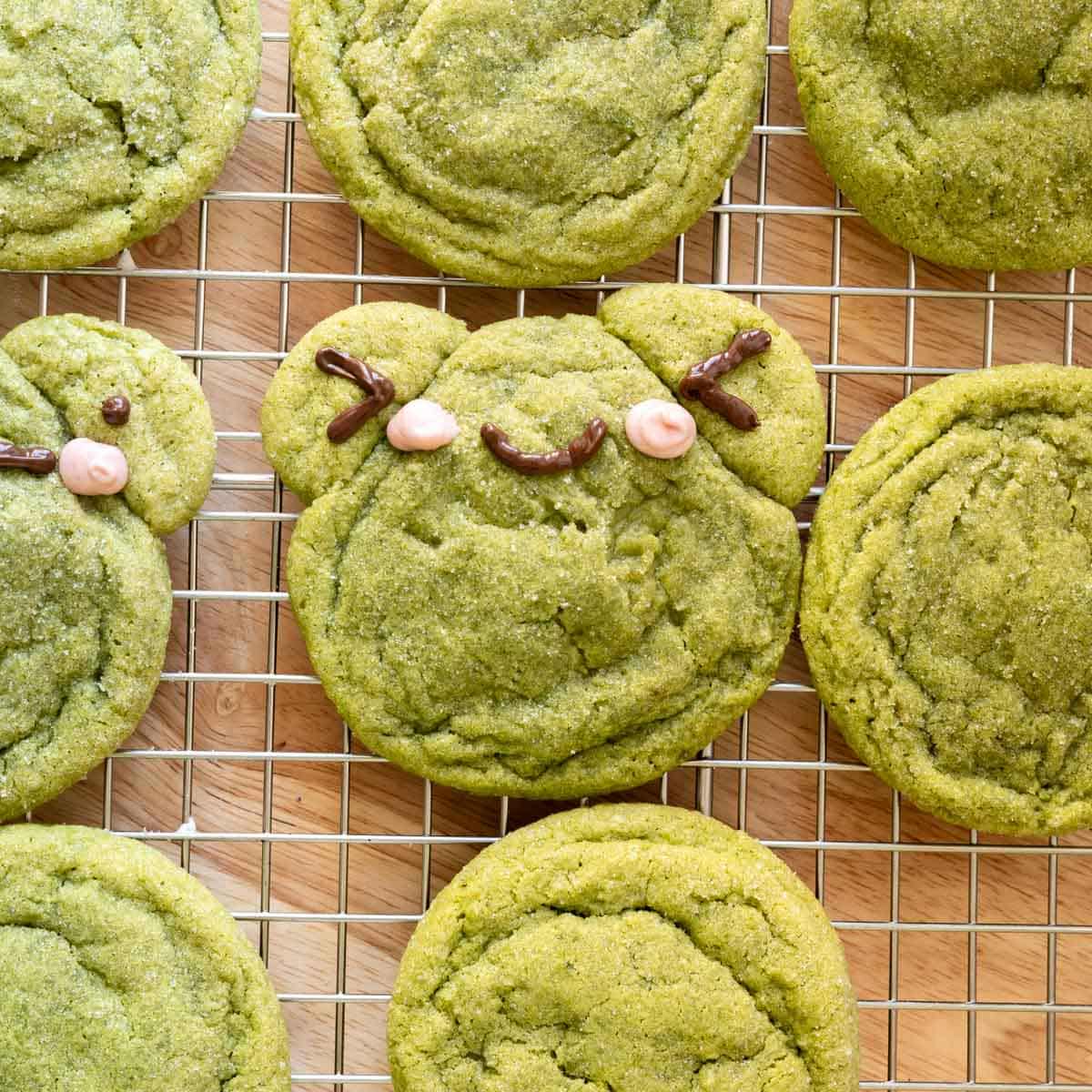 Frog matcha sugar cookies on a wire rack.