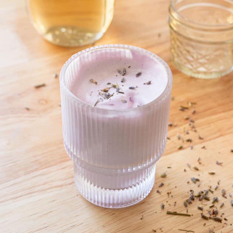Lavender cold foam in a glass cup, topped with dried lavender buds.