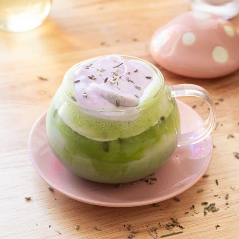 Lavender matcha latte in a glass cup.