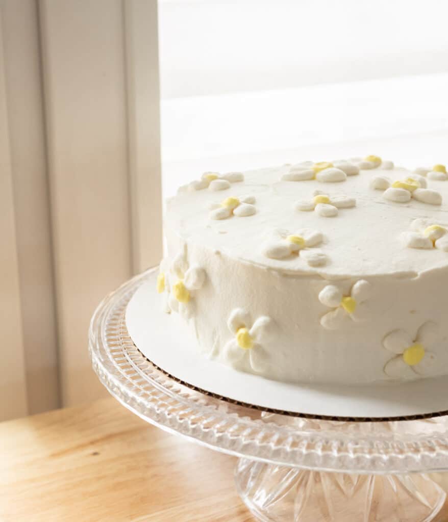 Frosted whipped cream cake with whipped cream flowers.
