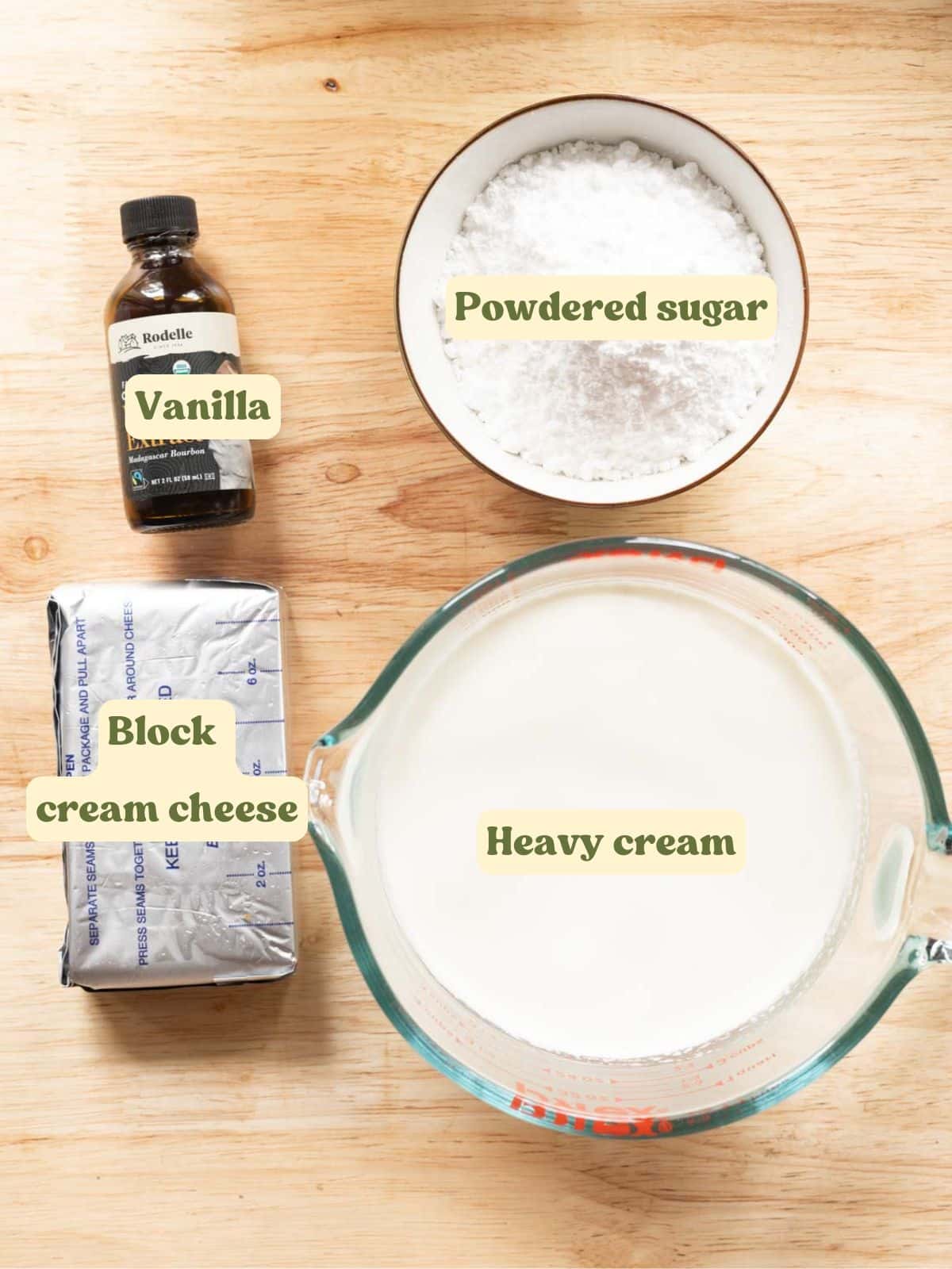 Stabilized whipped cream frosting labeled ingredients laid out on a wooden table.