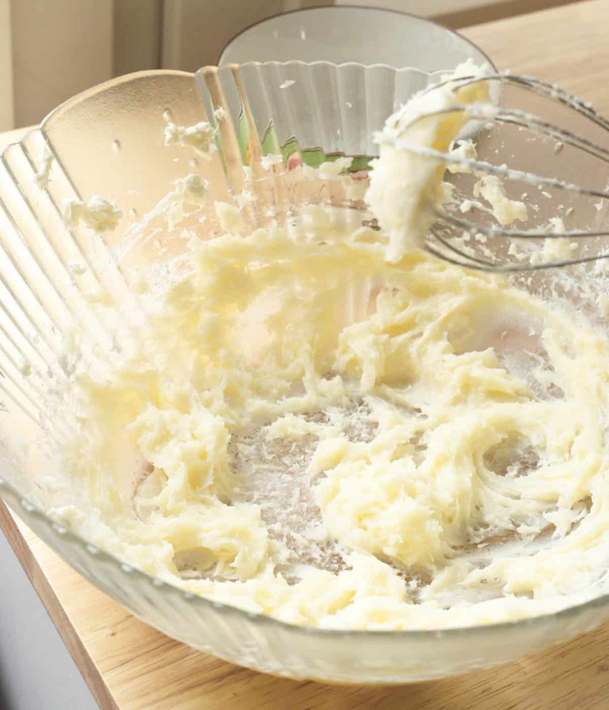 Whipped cream cheese and powdered sugar in mixing bowl.
