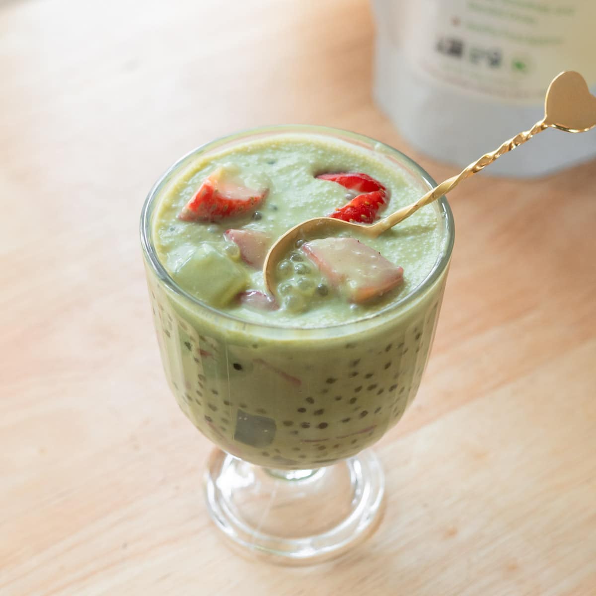 Strawberry matcha latte sago in a glass serving cup.