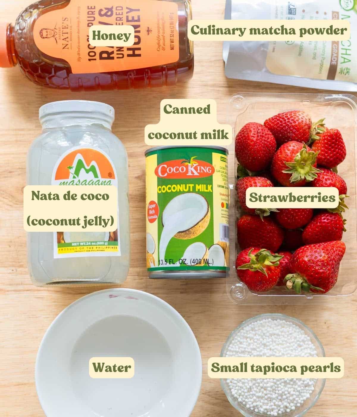 Strawberry matcha sago pudding ingredients on a wooden table.