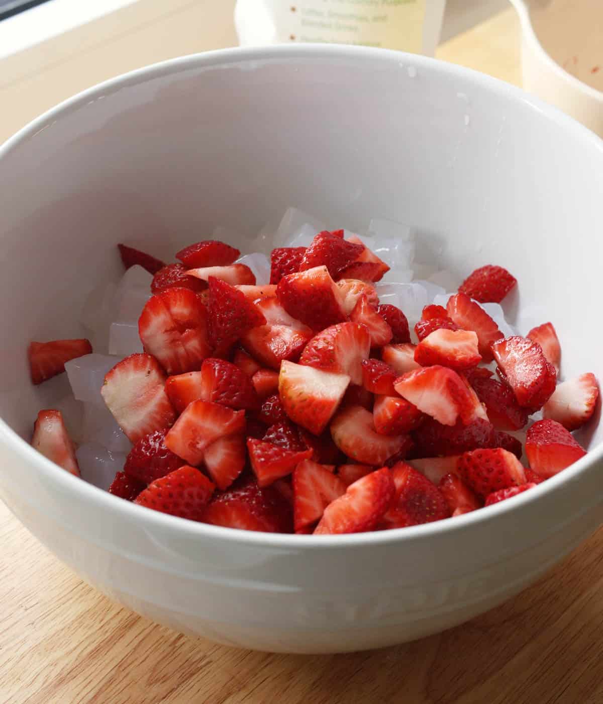 Mixing bowl with sago, diced strawberries, and coconut jellies.