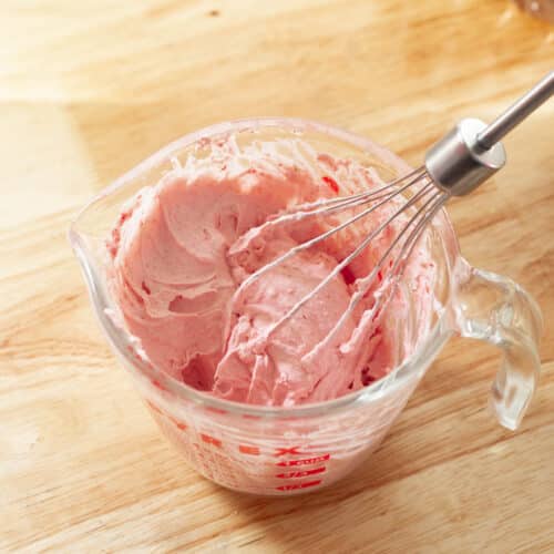 Strawberry whipped cream in a measuring cup.