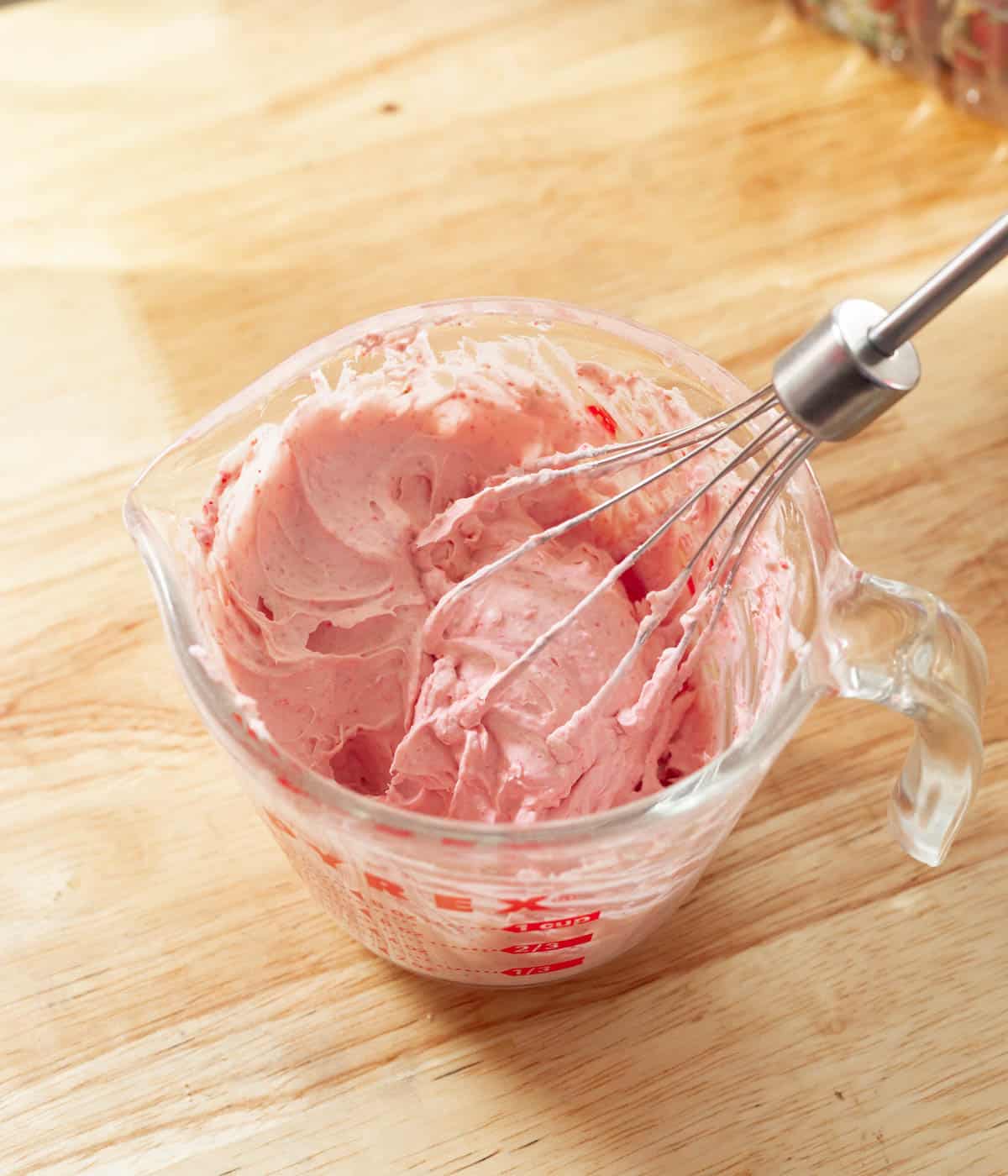 Strawberry whipped cream in a measuring cup.
