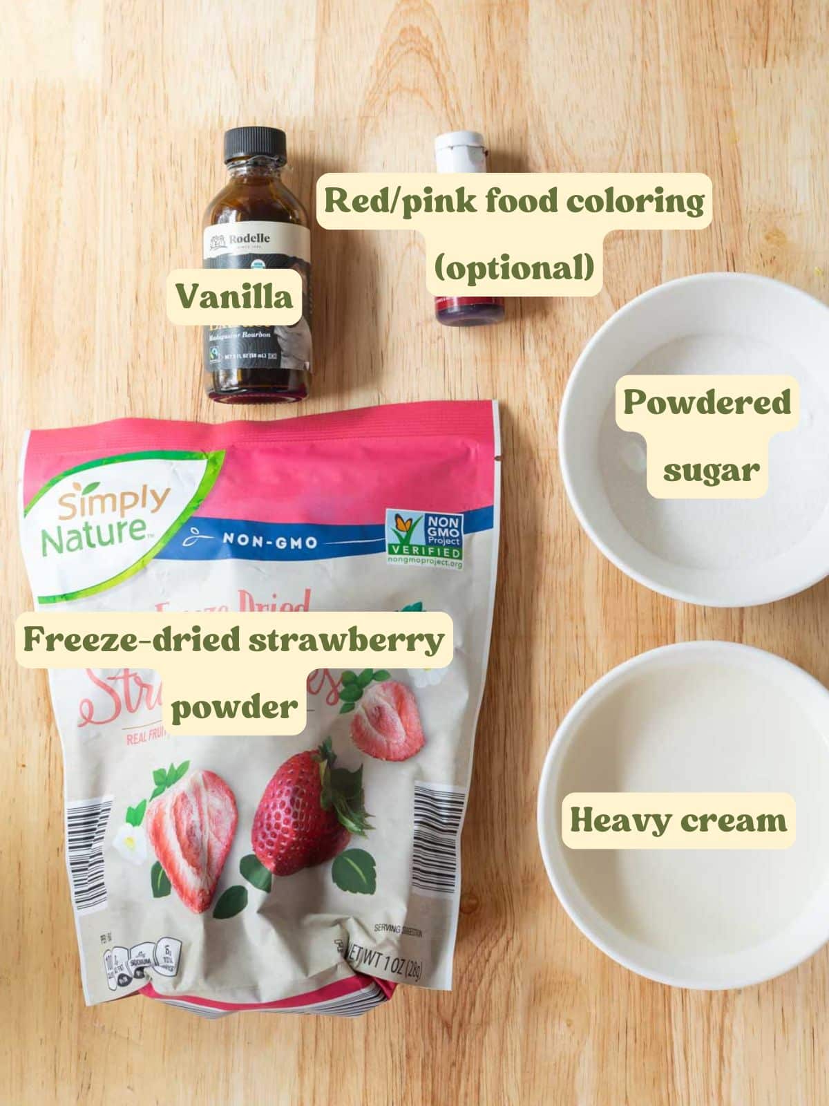 Strawberry whipped cream labeled ingredients laid out on a wooden table.
