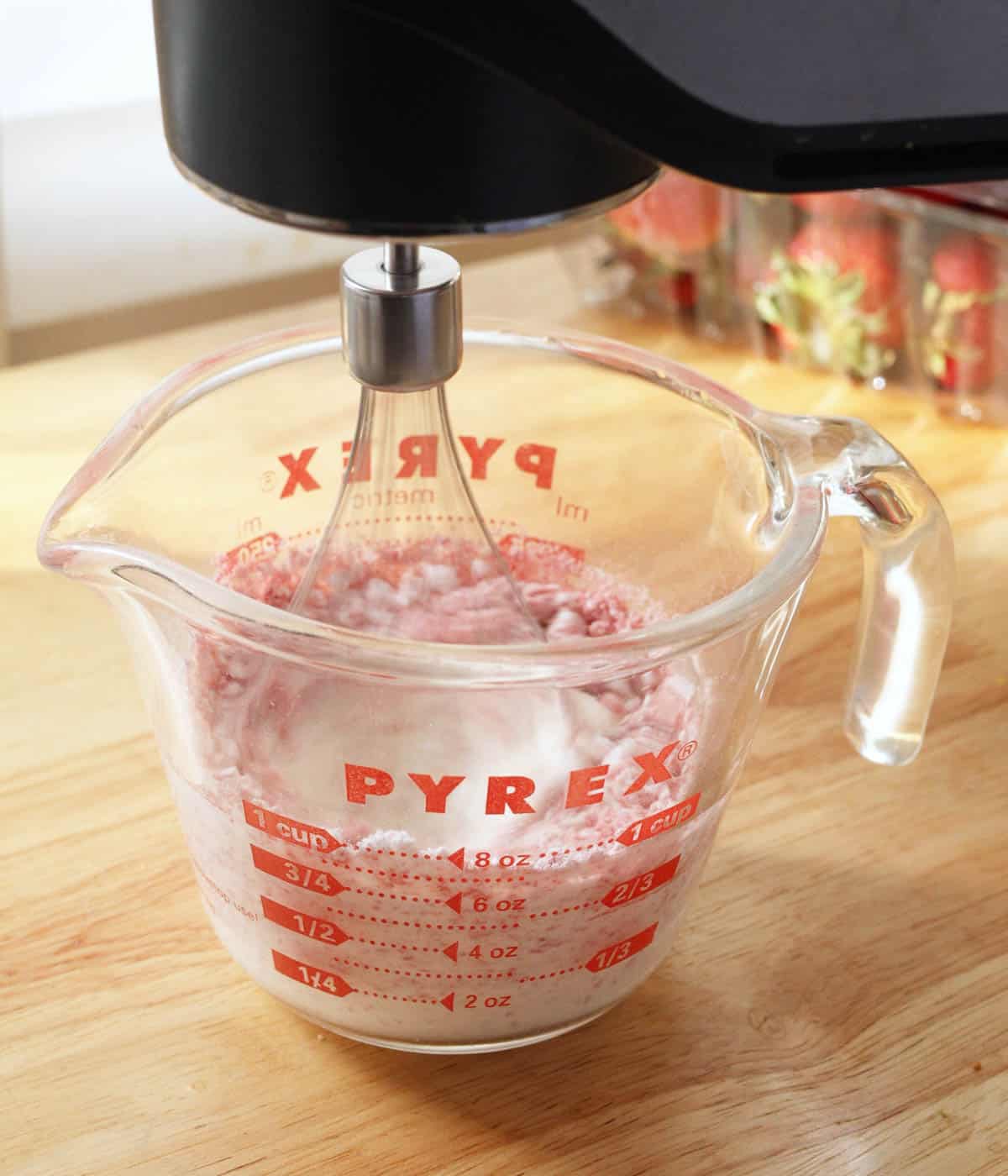 Using a hand mixer to whip all ingredients in a measuring cup.