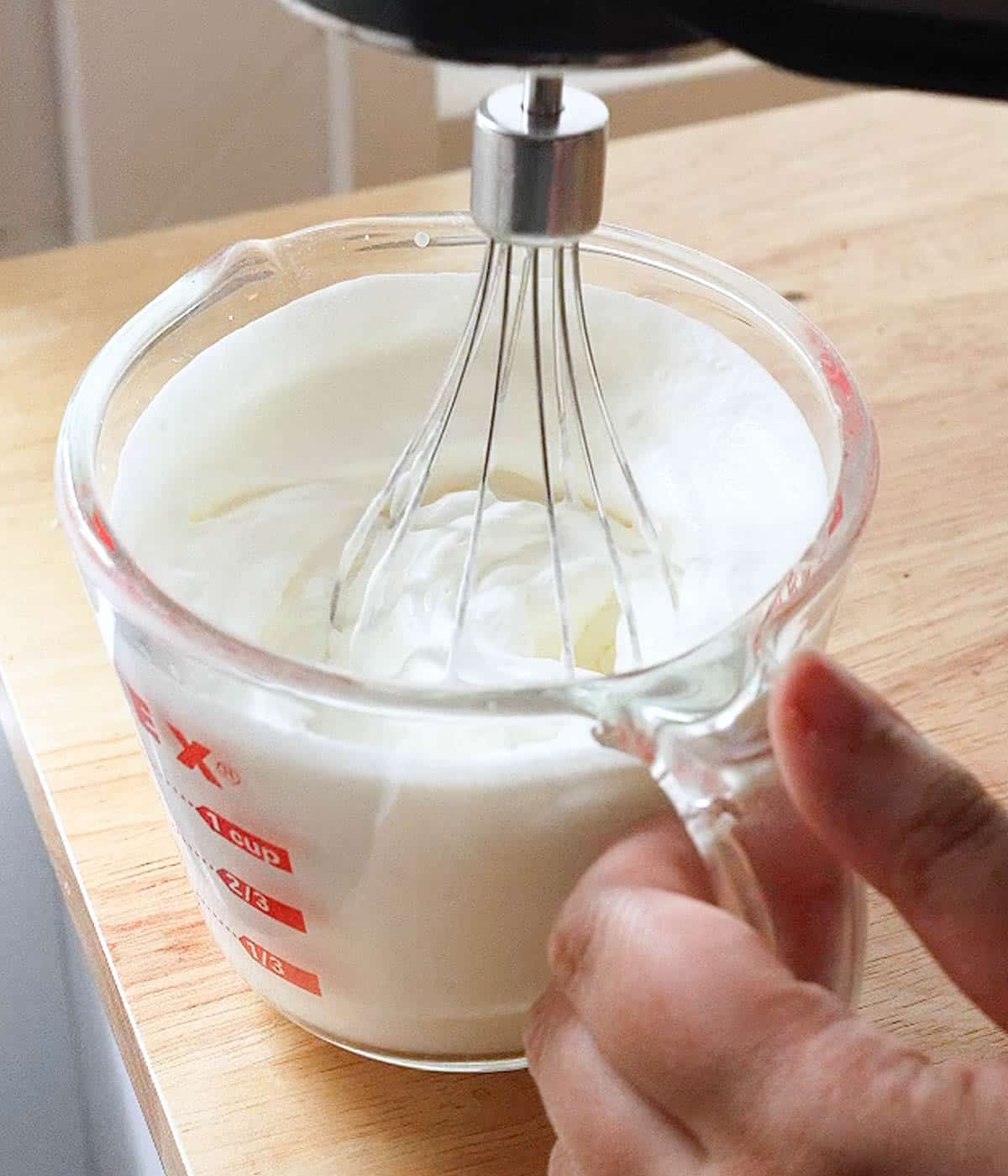 Whipping heavy cream with a hand mixer.