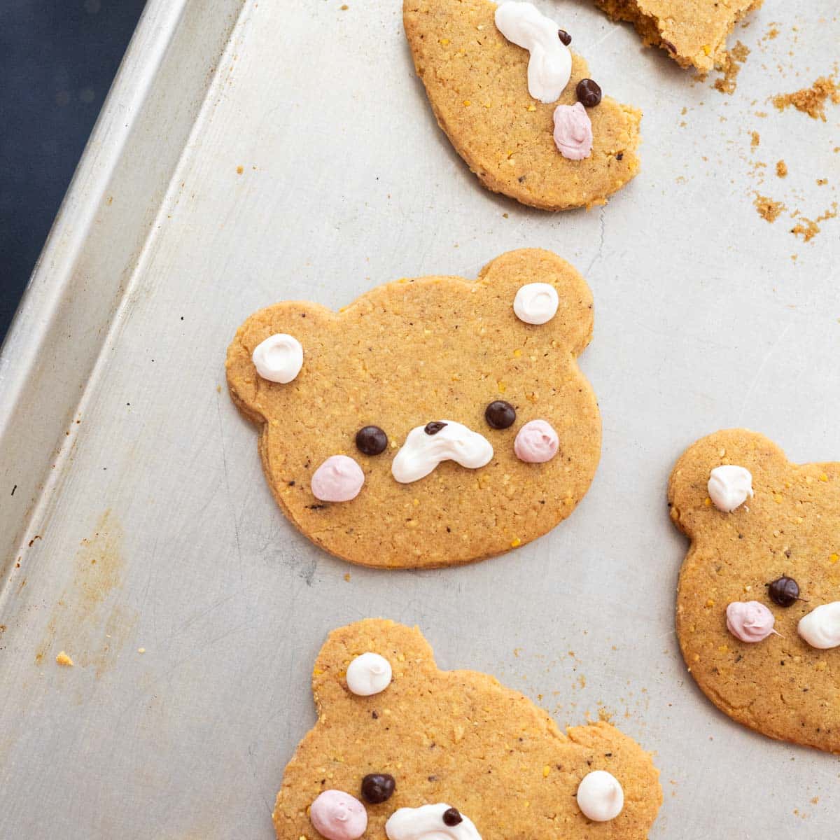 Roll out corn cookies on a cookie sheet, all decorated as bears.