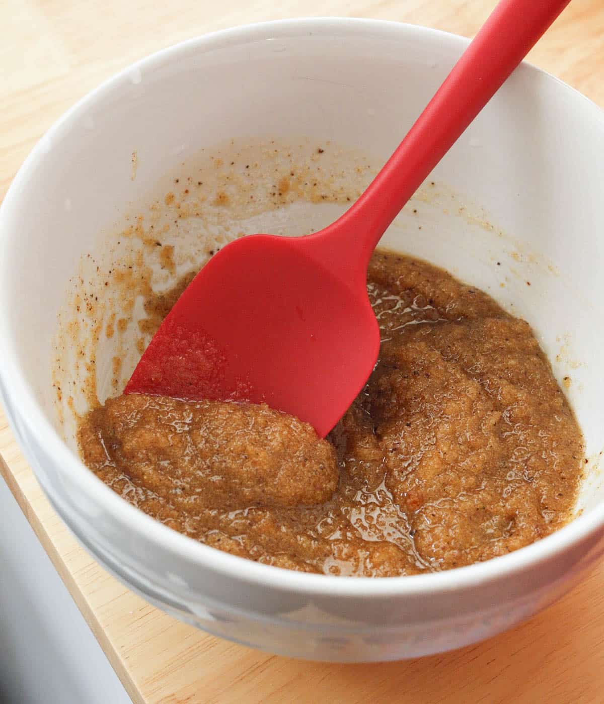 Brown butter and sugars mixed together until combined in a white bowl. 
