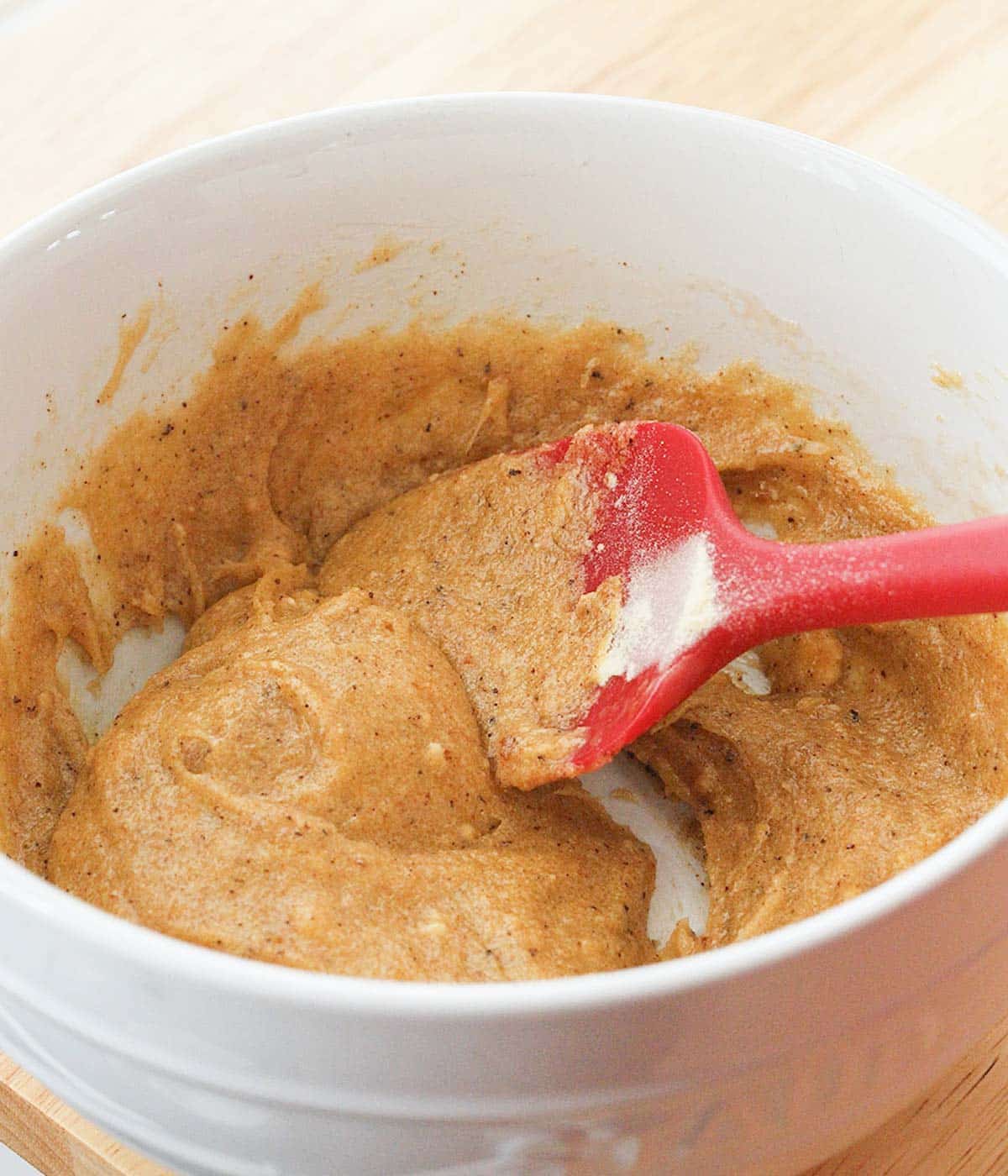 Fully combined wet ingredients in a white bowl, ready for dry ingredients to be added.
