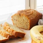 Banana bread loaf with some sliced pieces next to it.