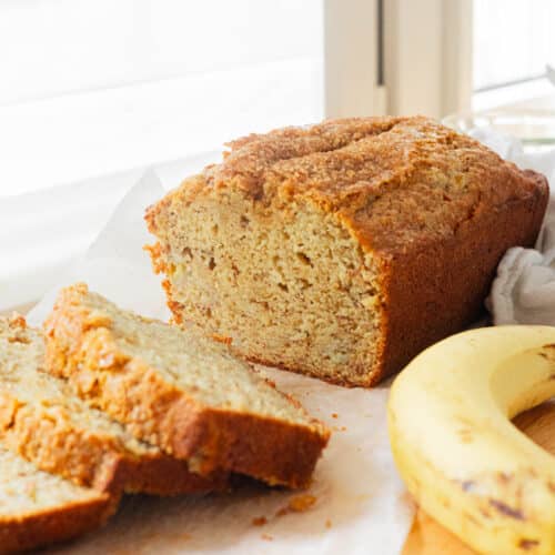 Banana bread loaf with some sliced pieces next to it.