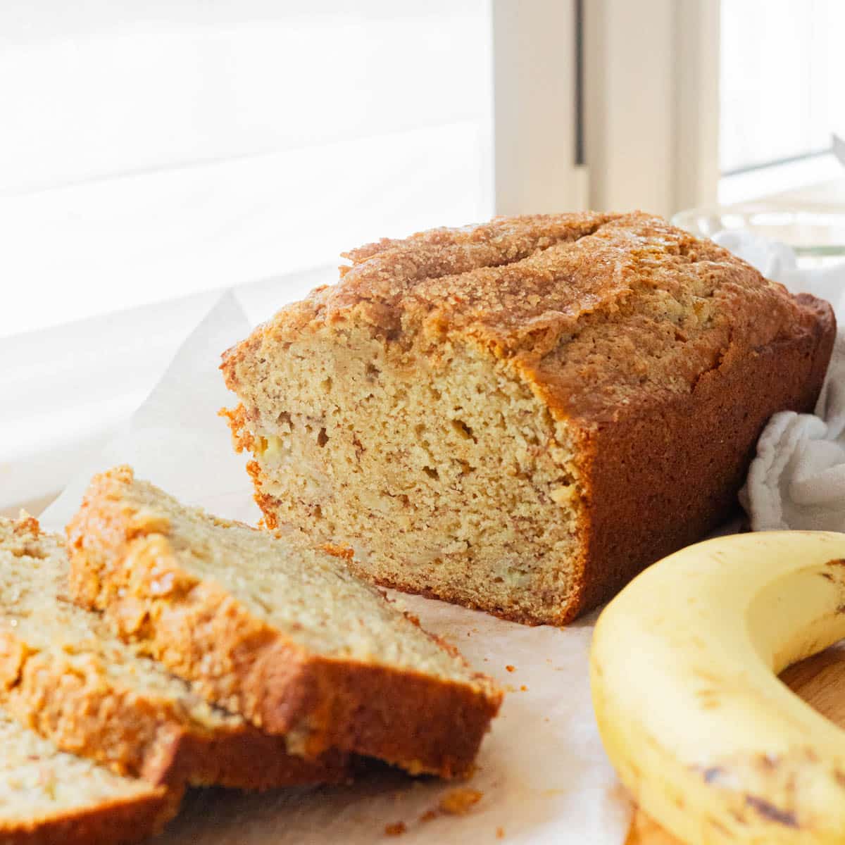 Banana bread loaf with some sliced pieces next to it.