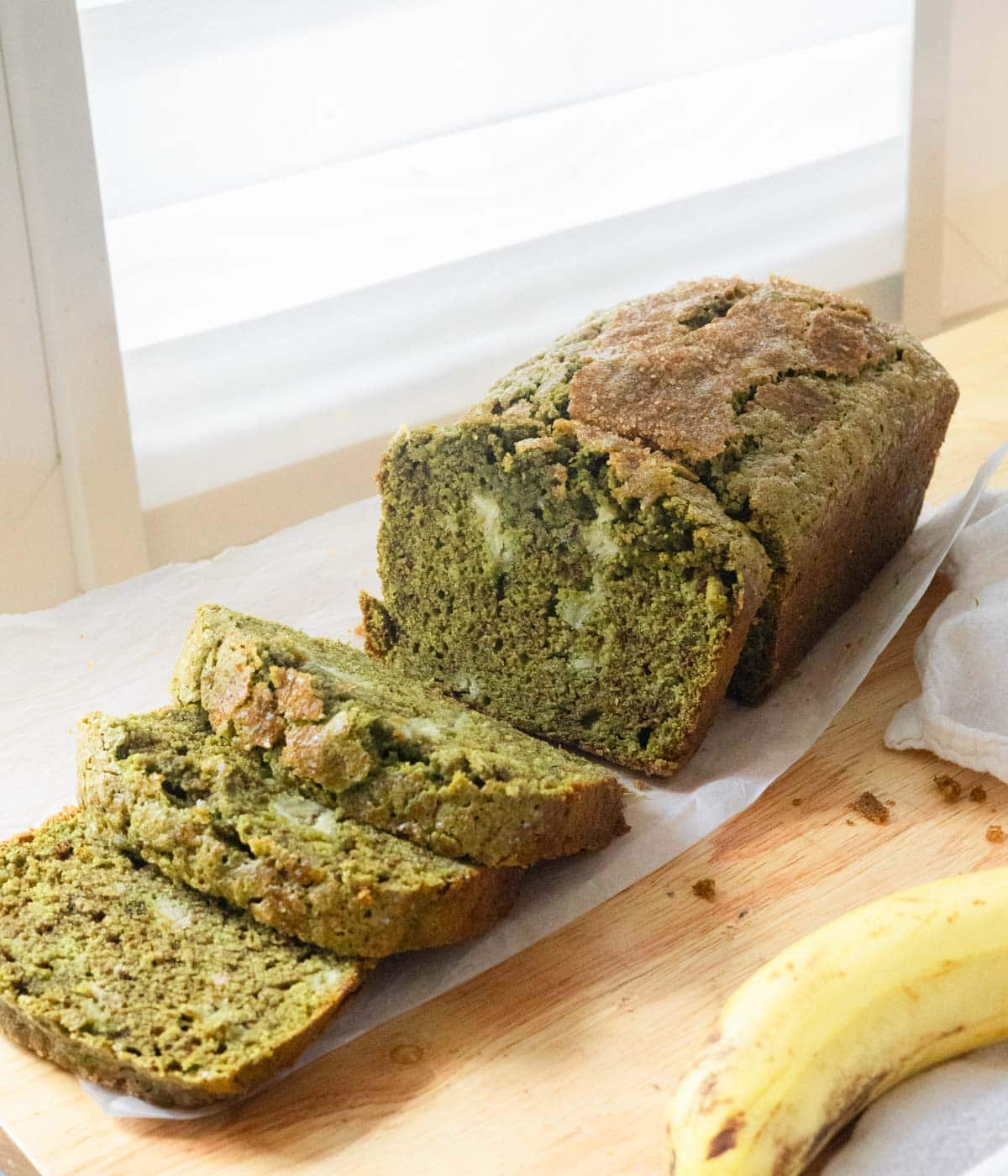 Matcha banana bread with half of it cut into slices.