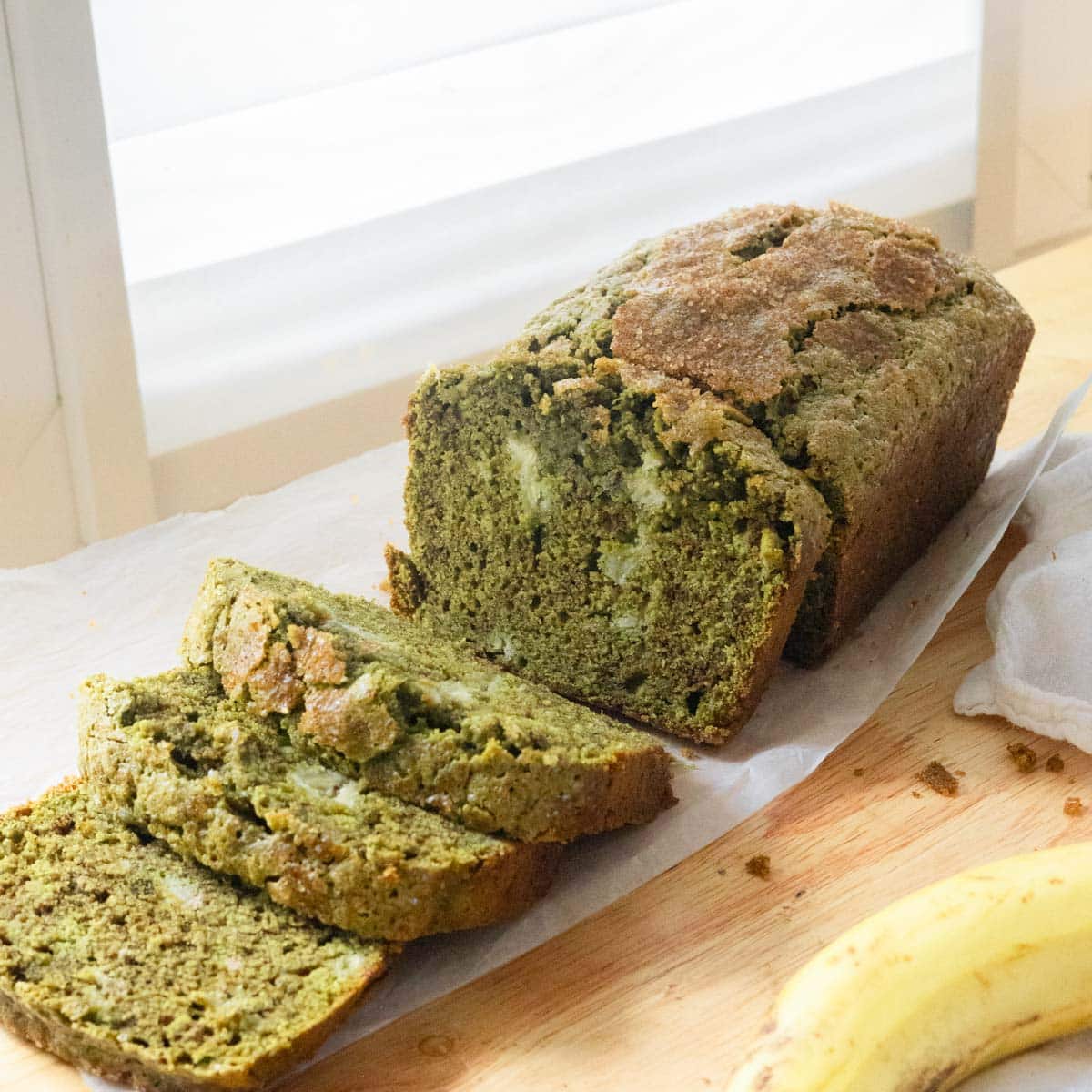 Matcha banana bread with half of it cut into slices.