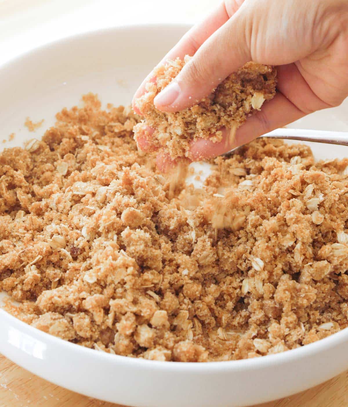 Homemade crumble topping in white bowl.