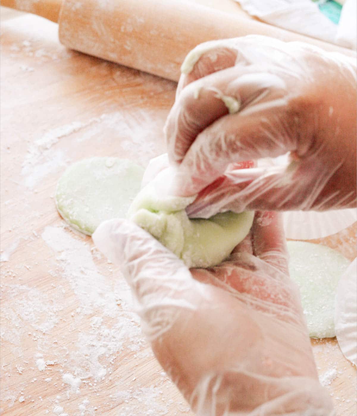 Wrapping mint mochi dough around a ball of ice cream.