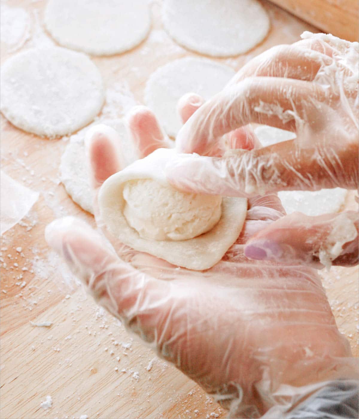 Wrapping mochi dough around a ball of ice cream.