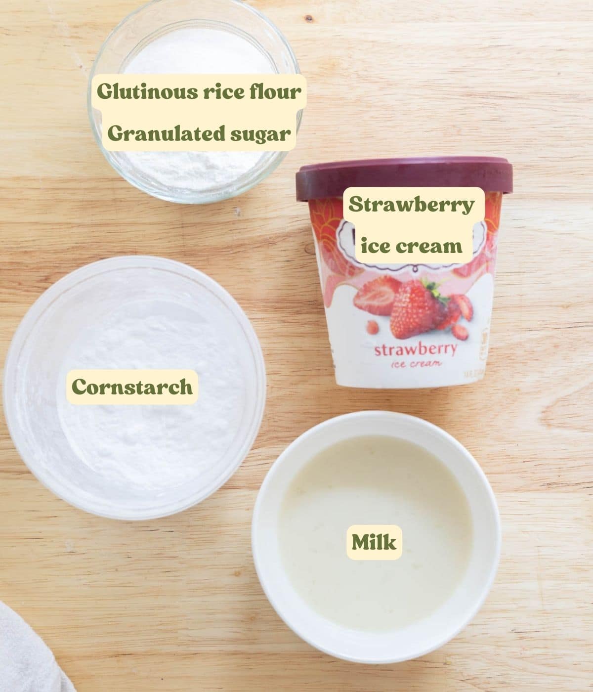 Labeled strawberry mochi ice cream ingredients laid out on wooden table.