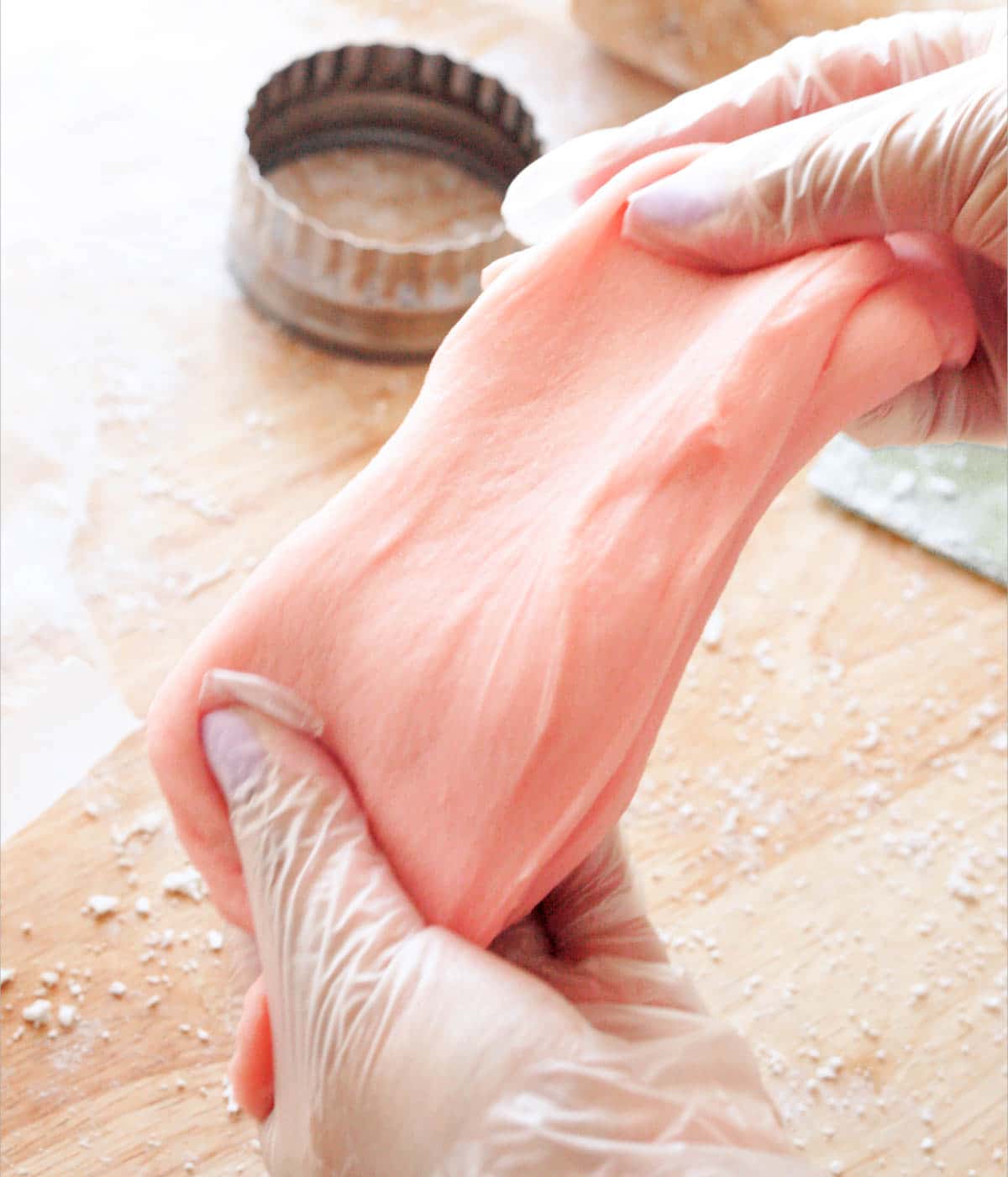 Kneading strawberry mochi dough in between hands.