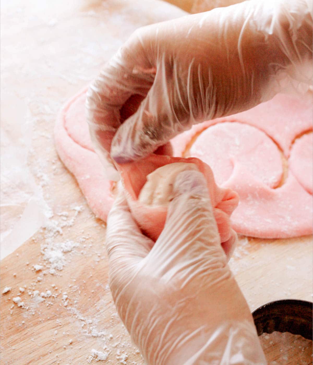Wrapping strawberry mochi dough around a ball of ice cream.