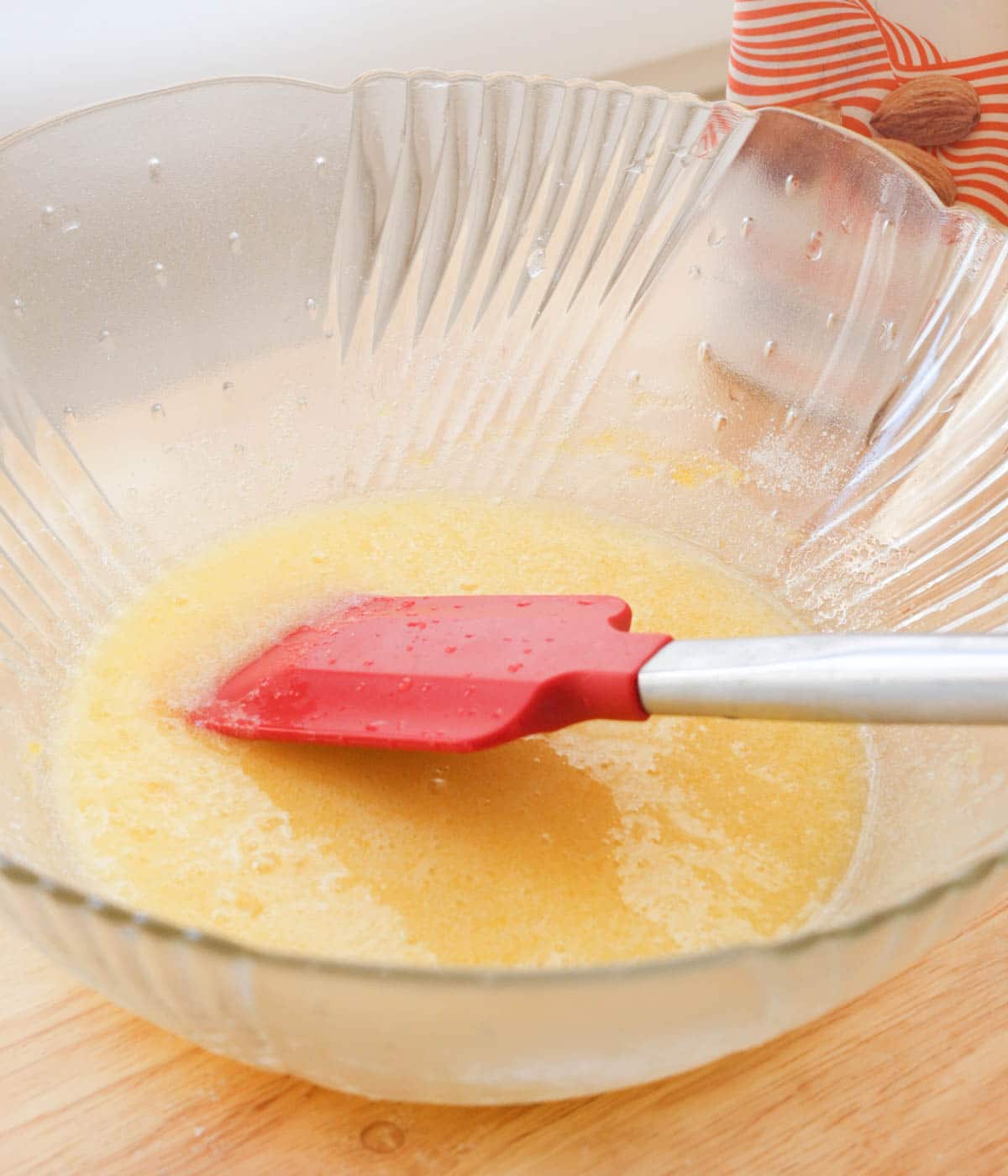 Egg and sugar mixed together in glass mixing bowl.
