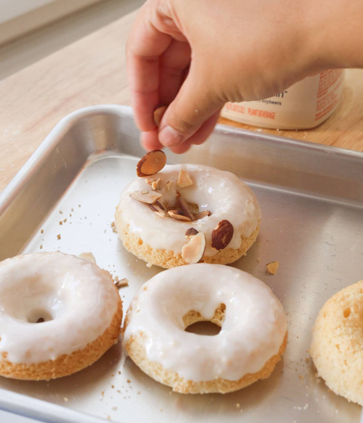 Topping almond mochi donut with sliced almonds.