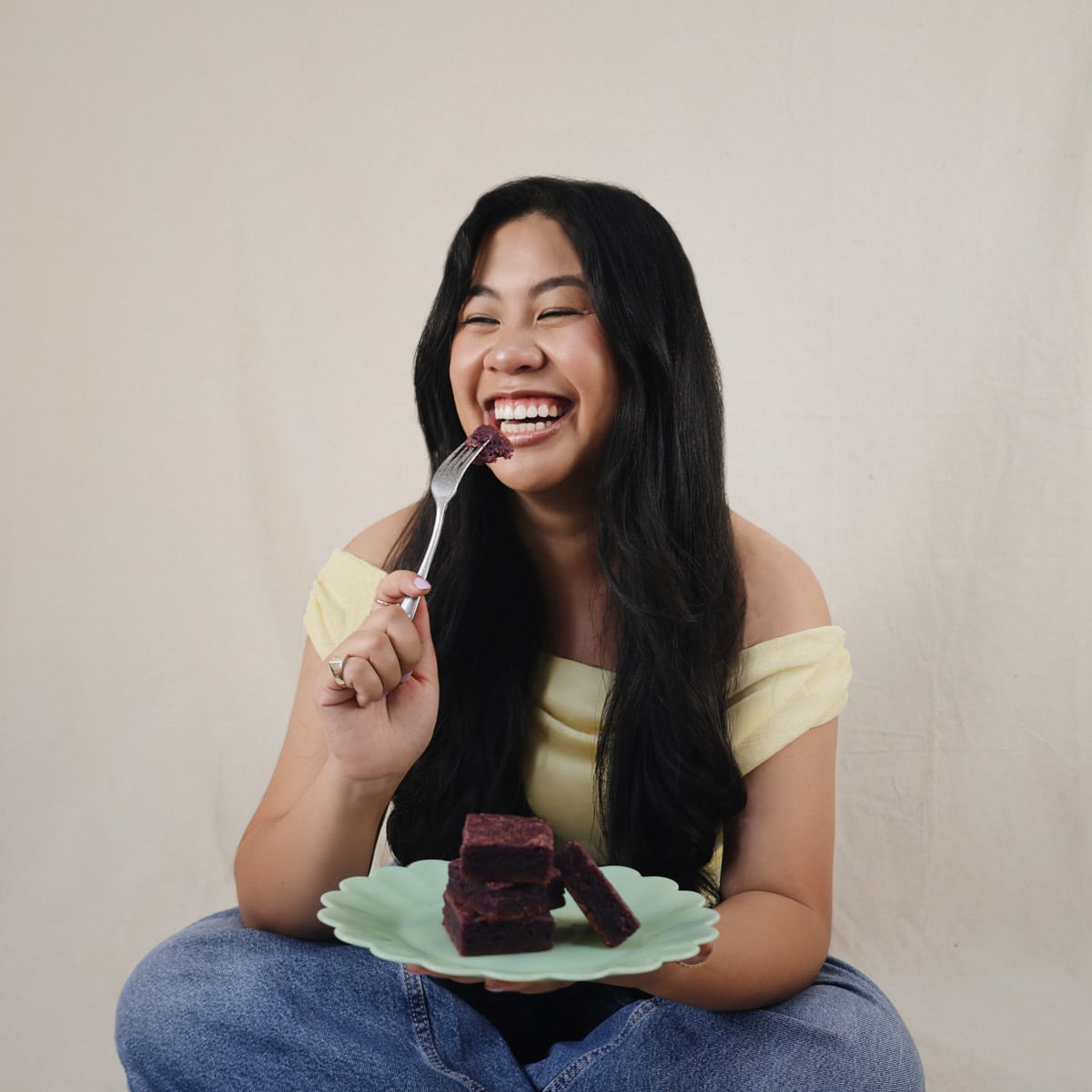 Bites by Bianca taking bite of Oh So Easy Ube Blondies with a fork.