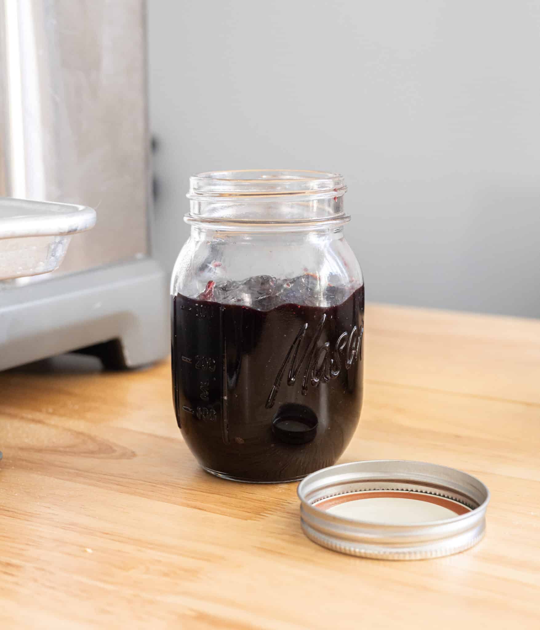 Dark cherry jam in a glass mason jar.