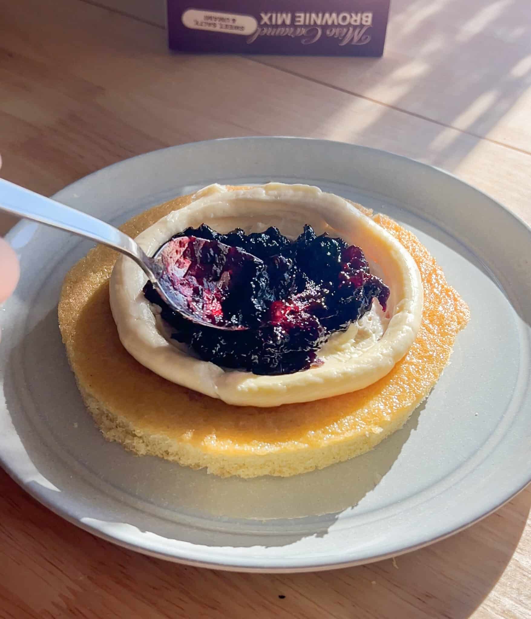 Spreading cherry jam onto Spiced Yellow Cake layer.