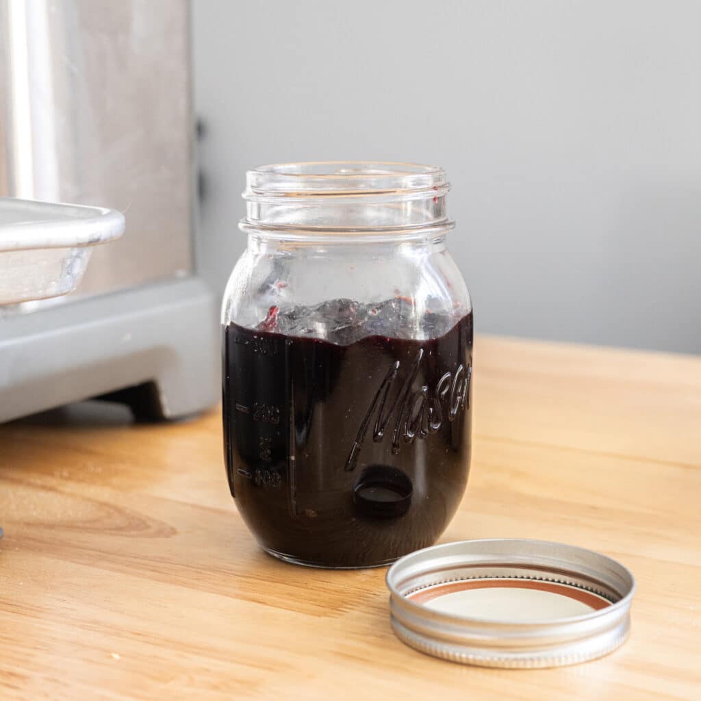 Dark cherry jam in a glass mason jar.