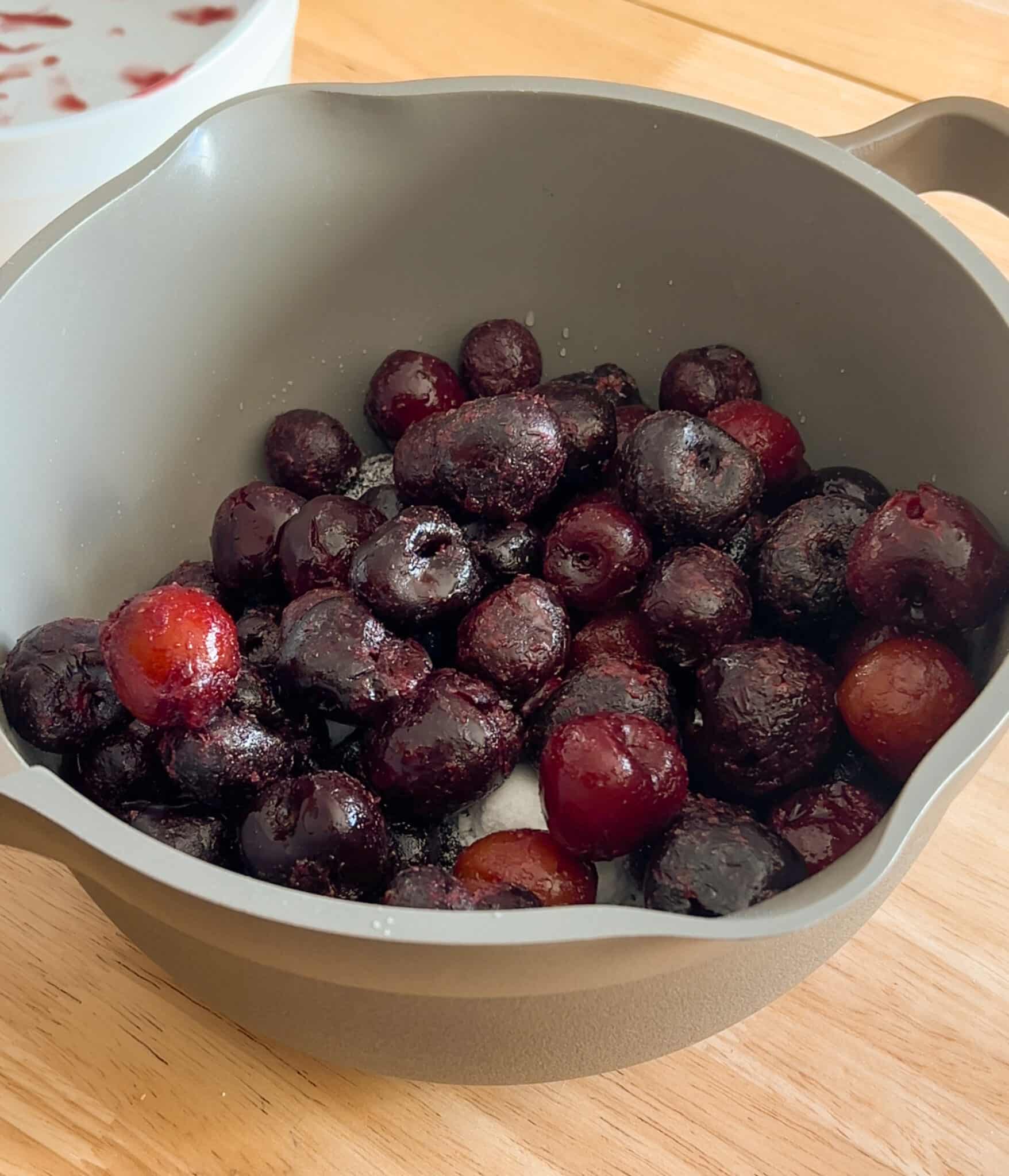 Cherry jam ingredients mixed together in a saucepan.