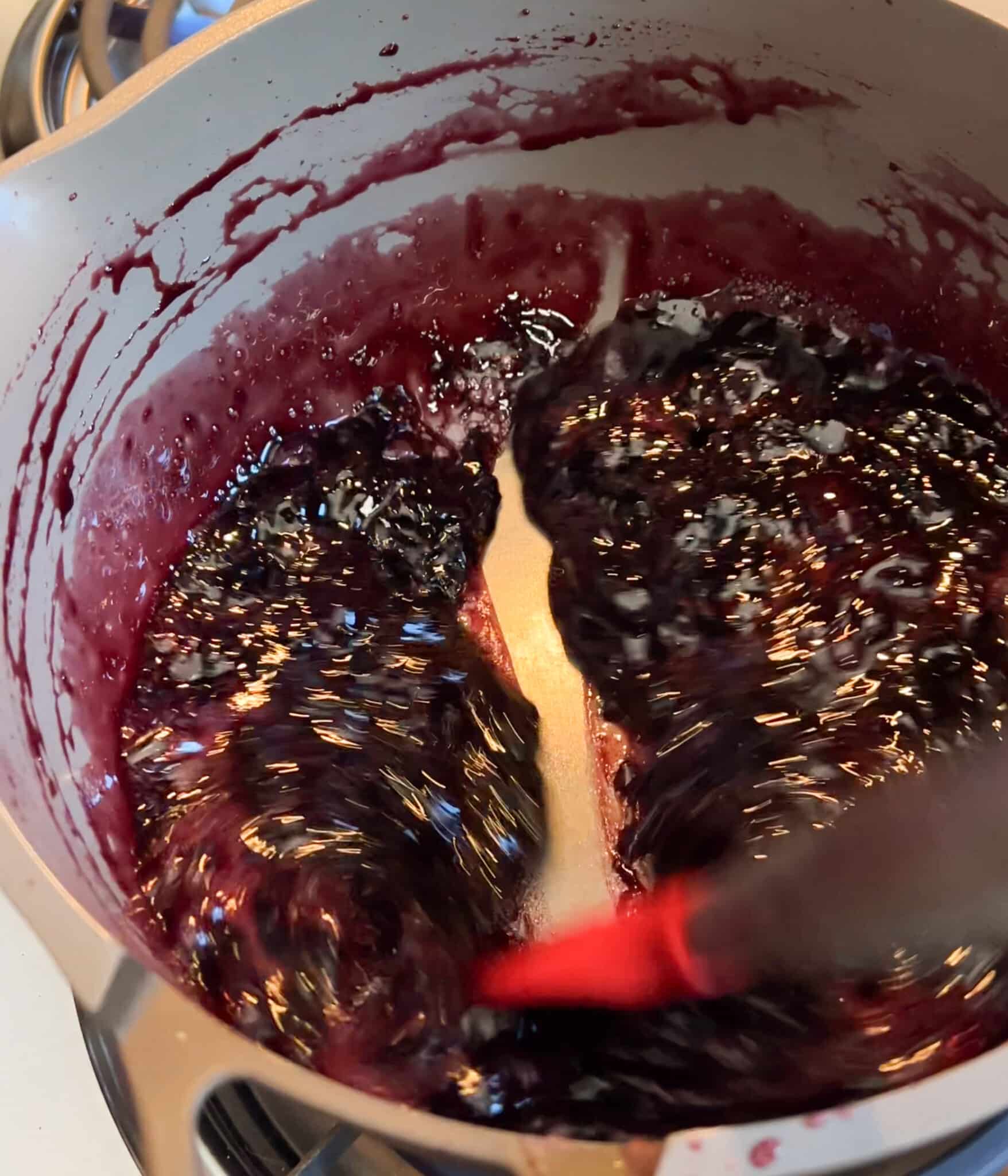 Thick cherry jam in a saucepan.
