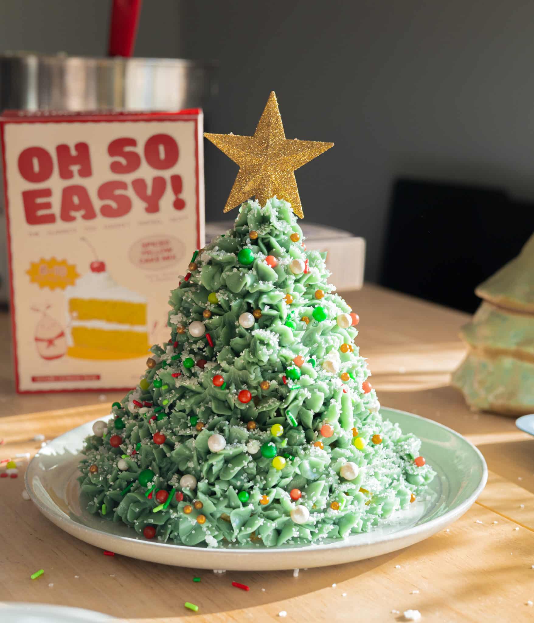 Christmas tree cake decorated with Swiss meringue buttercream and sprinkles.
