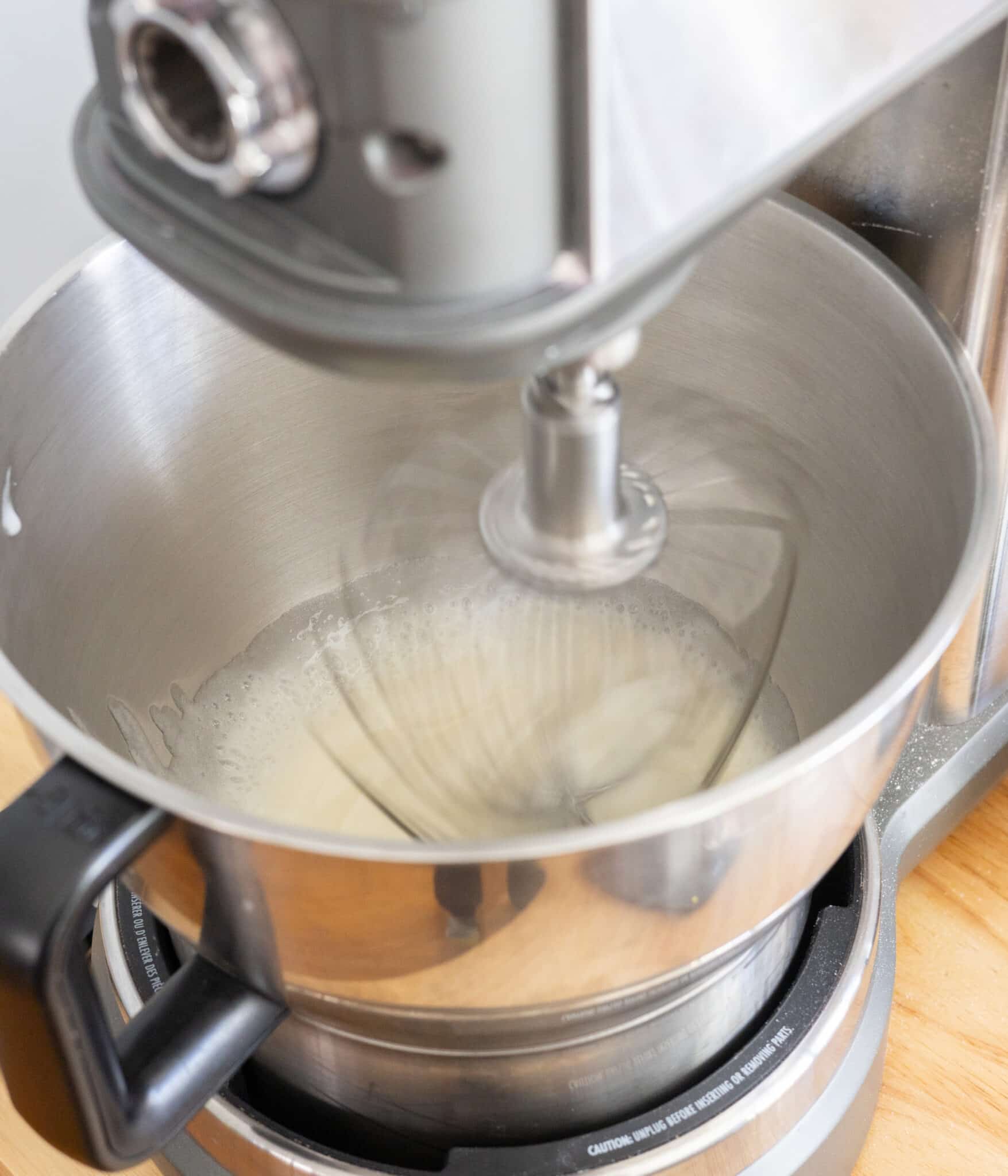 Whipping egg whites and dissolved sugar in a stand mixer.