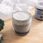 Black sesame latte topped with cheese foam in a glass cup.