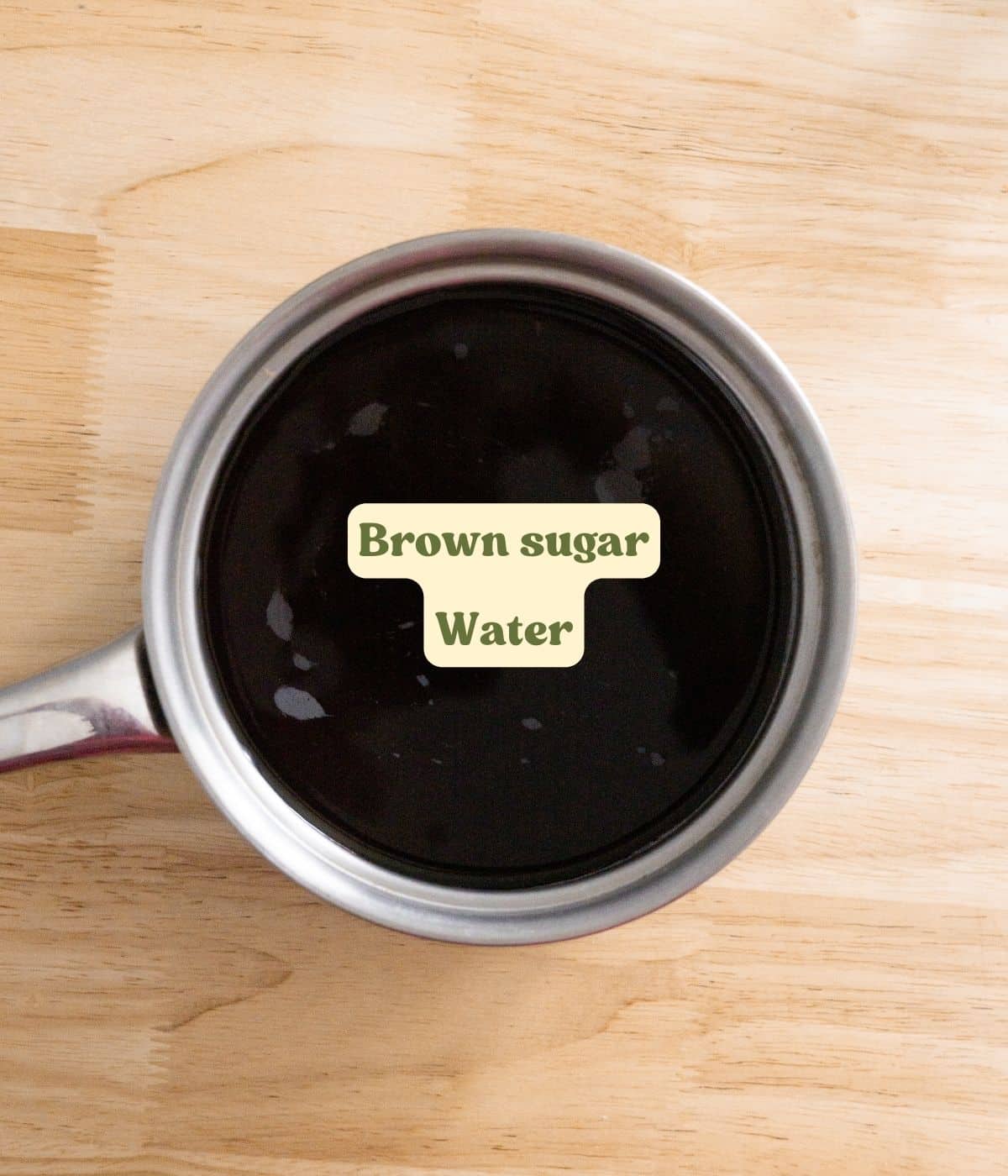 Labeled brown sugar simple syrup ingredients laid out on wooden table.